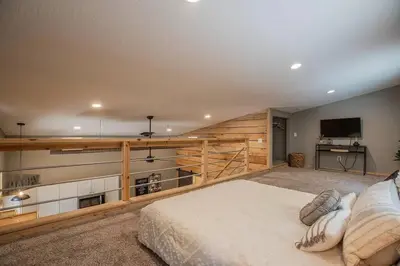 a bedroom with a large bed and a television at Nature's Nest - Woodsy Retreat w/ Renovated Deck & Hot Tub in Logan