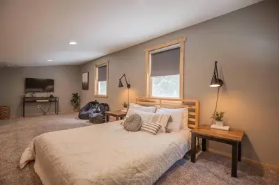 a bedroom with a large bed with pillows on it at Nature's Nest - Woodsy Retreat w/ Renovated Deck & Hot Tub in Logan