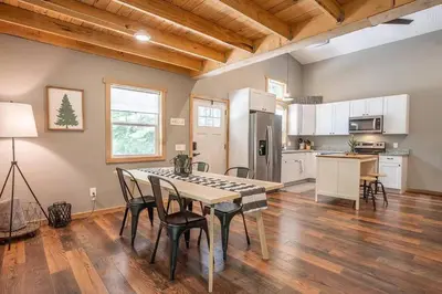 a kitchen and dining room with a table and chairs at Nature's Nest - Woodsy Retreat w/ Renovated Deck & Hot Tub in Logan