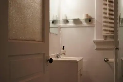 a white bathroom with a sink and a mirror at Cute Charming Vintage Townhome in German Village in Columbus