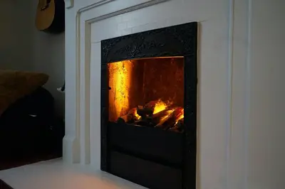 a fireplace with a fire inside of it at Cute Charming Vintage Townhome in German Village in Columbus