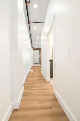 an empty hallway with white walls and wood floors at American Hall in Millersburg