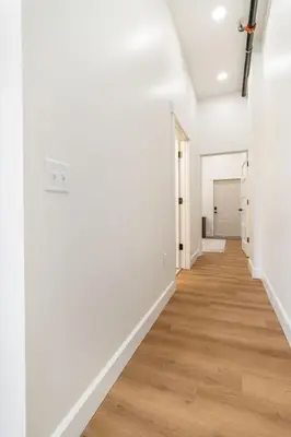 an empty hallway with white walls and wood floors at American Hall in Millersburg