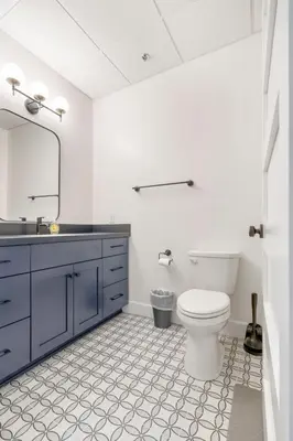 a bathroom with a toilet and a sink and a mirror at American Hall in Millersburg