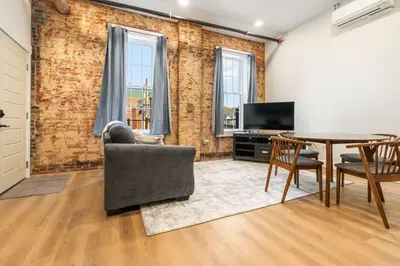 a living room with a table and chairs and a television at Young Suite in Millersburg