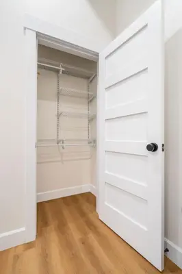 a closet with white doors and a wooden floor at Young Suite in Millersburg