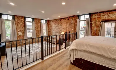 a bedroom with a balcony with a bed and windows at Kaufman Suite- BY BUSY INTERSECTION in Millersburg
