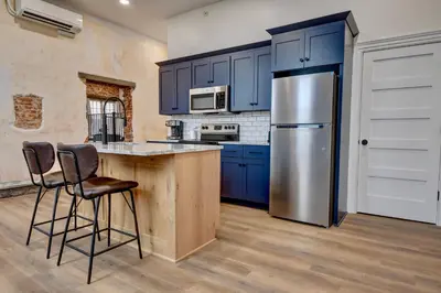 a kitchen with blue cabinets and a stainless steel refrigerator at Kaufman Suite- BY BUSY INTERSECTION in Millersburg