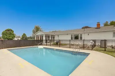 a swimming pool in front of a house at Quiet Greenwich Home with Pool and Screened Porch! in Greenwich