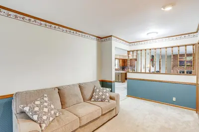 a living room with a couch and a kitchen at Quiet Greenwich Home with Pool and Screened Porch! in Greenwich