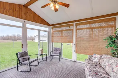 a living room with a couch and chairs and windows at Quiet Greenwich Home with Pool and Screened Porch! in Greenwich
