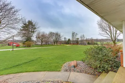 a yard with a field of grass and a house at Quiet Greenwich Home with Pool and Screened Porch! in Greenwich
