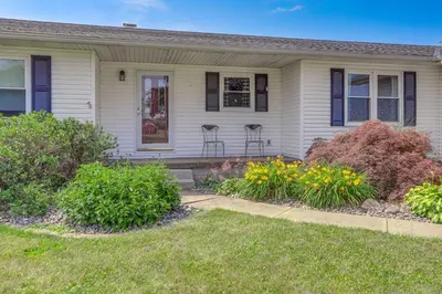 a white house with flowers in front of it at Quiet Greenwich Home with Pool and Screened Porch! in Greenwich