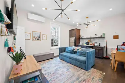 a living room with a blue couch and a kitchen at 1BR with Kitchen & Free Parking - Walk Everywhere in Covington