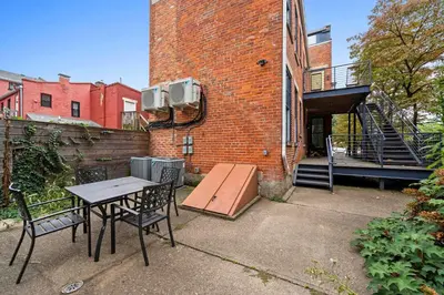 a patio with a table and chairs in front of a brick building at 1BR with Kitchen & Free Parking - Walk Everywhere in Covington