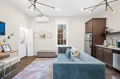 a living room with a blue couch in a kitchen at 1BR with Kitchen & Free Parking - Walk Everywhere in Covington