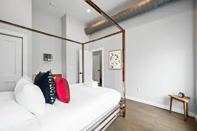 a bedroom with a white bed with red pillows at 1BR with Parking - Walk to Convention Center & Stadiums in Covington