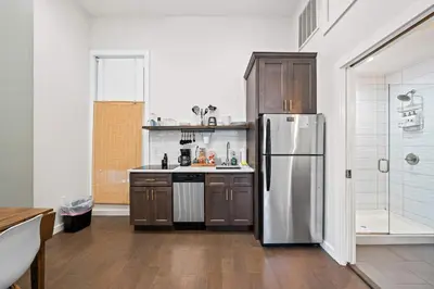 a kitchen with a stainless steel refrigerator and wooden cabinets at 1BR with Parking - Walk to Convention Center & Stadiums in Covington