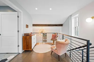 a living room with a chair and a staircase at Downtown Views - Walk to Stadiums & Convention Center in Covington
