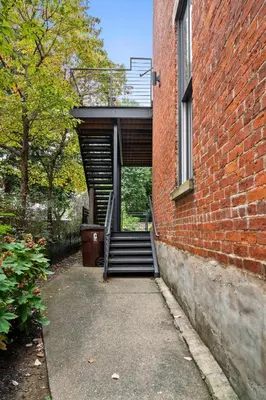 a brick building with a stairway leading into a building at Downtown Views - Walk to Stadiums & Convention Center in Covington