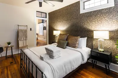 a bedroom with a large bed with a wall at Walk to Downtown, Bars, Stadiums - Perfect for 4! in Covington