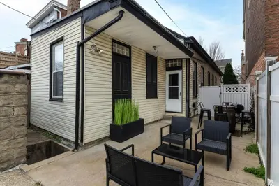 a tiny house with a patio with chairs and a table at Walk to Downtown, Bars, Stadiums - Perfect for 4! in Covington