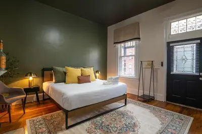 a bedroom with a bed and a chair and a door at Walk to Downtown, Bars, Stadiums - Perfect for 4! in Covington
