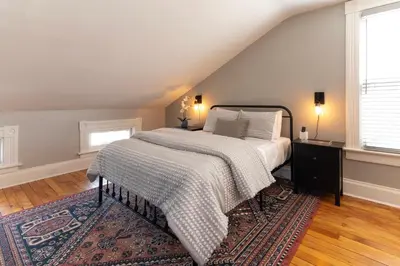 a bedroom with a bed and a rug at Main Street 2BR, Walk to Bars, Stadiums, Downtown in Covington