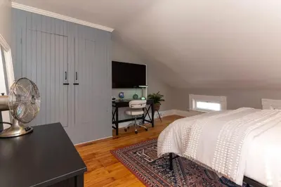 a bedroom with a bed and a desk with a fan at Main Street 2BR, Walk to Bars, Stadiums, Downtown in Covington