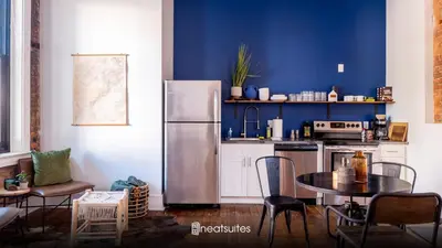 a kitchen with a refrigerator and a table with chairs at Downtown Covington - Near Shopping, Bars, Cincinnati in Covington