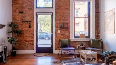 a brick wall with two chairs and a door at Downtown Covington - Near Shopping, Bars, Cincinnati in Covington