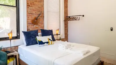 a bedroom with a bed with blue and white pillows at Downtown Covington - Near Shopping, Bars, Cincinnati in Covington