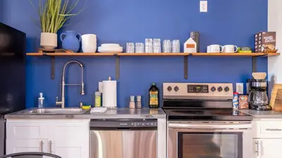 a kitchen with a stove and a sink and a blue wall at Downtown Covington - Near Shopping, Bars, Cincinnati in Covington