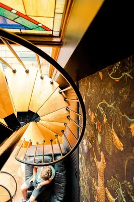a couple sitting on a spiral staircase with a mural at 4BR Bridal, Group Retreat - Walkable - Skyline Views in Cincinnati