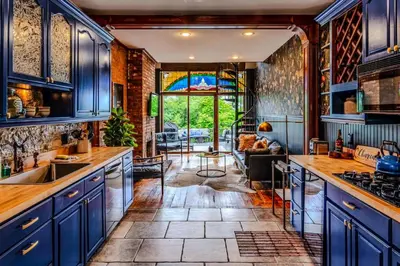 a kitchen with blue cabinets and a living room at 4BR Bridal, Group Retreat - Walkable - Skyline Views in Cincinnati