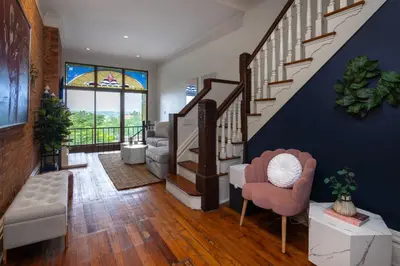 a living room with a staircase and a blue wall at 4BR Bridal, Group Retreat - Walkable - Skyline Views in Cincinnati