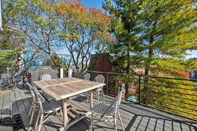 a wooden table and chairs on a balcony with trees at Clawfoot Tub, Next to Monastery Wedding Venue, 3BR in Cincinnati