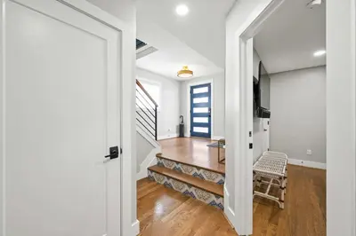 a hallway with white walls and a staircase with a chair at Clawfoot Tub, Next to Monastery Wedding Venue, 3BR in Cincinnati