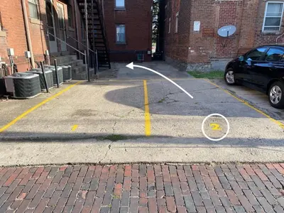 a parking lot with a car parked in front of a building at 2BR Townhome with Parking - Walk to Stadiums & Downtown in Covington