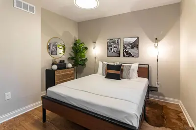 a bedroom with a bed with white sheets and a mirror at 2BR Townhome with Parking - Walk to Stadiums & Downtown in Covington