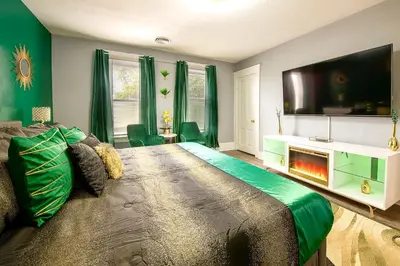 a bedroom with a large bed with a fireplace at The Tremont Emerald - By Christmas Story House - Historic Charm & Modern Comfort Near Downtown With Parking, 300MB Wifi & Self Check-In in Cleveland