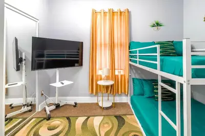 a bedroom with a bunk bed and a television at The Tremont Emerald - By Christmas Story House - Historic Charm & Modern Comfort Near Downtown With Parking, 300MB Wifi & Self Check-In in Cleveland