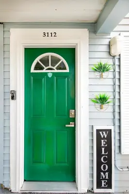 a green door on a house with a sign at The Tremont Emerald - By Christmas Story House - Historic Charm & Modern Comfort Near Downtown With Parking, 300MB Wifi & Self Check-In in Cleveland