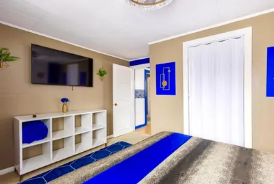 a bedroom with a bed and a tv on the wall at The Sapphire Haven - Your Old Brooklyn Oasis Awaits Families, Couples, Business Travelers Near Downtown With Parking, 300 MB WiFi & Self Check-In in Cleveland