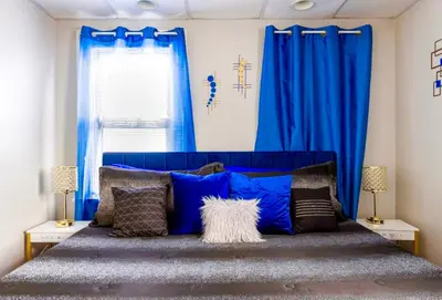 a bedroom with a blue bed with blue curtains at The Sapphire Haven - Your Old Brooklyn Oasis Awaits Families, Couples, Business Travelers Near Downtown With Parking, 300 MB WiFi & Self Check-In in Cleveland