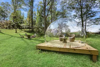 a glass dome on a wooden table in the grass at Cabin with King Bed , XBOX, HotTub, Games, Firepit , Stargazing Dome in Logan