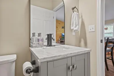 a bathroom with a sink and a mirror at Cabin with King Bed , XBOX, HotTub, Games, Firepit , Stargazing Dome in Logan