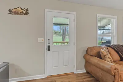a living room with a door and a couch at Cabin with King Bed , XBOX, HotTub, Games, Firepit , Stargazing Dome in Logan