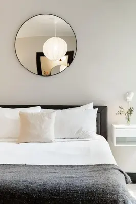 a bedroom with a large mirror above a bed at Lux Parkside 1BR - Patio - Sun Deck - Free Parking in Cincinnati