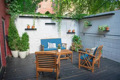 a wooden table and chairs on a patio at Lux Parkside 1BR - Patio - Sun Deck - Free Parking in Cincinnati